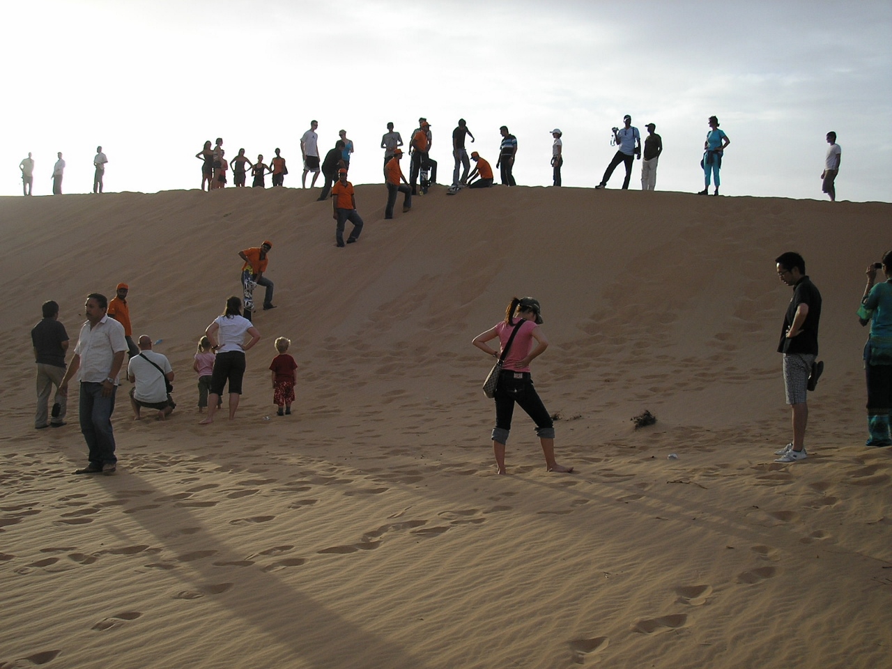 tourist slide down sand dune dubai uae jun 2007