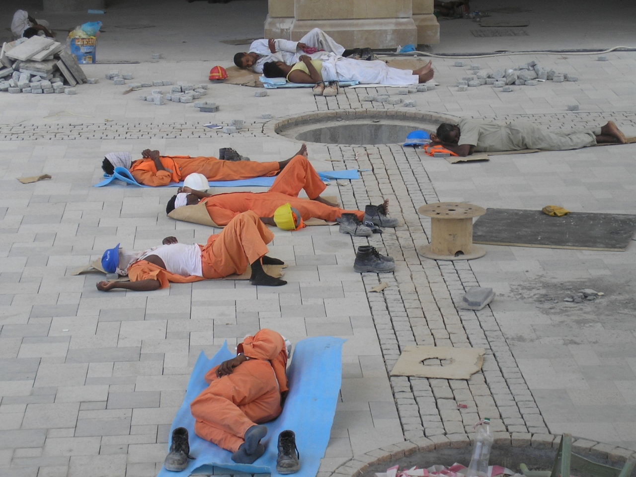 workers resting on tiles dubai uae Jun 2007